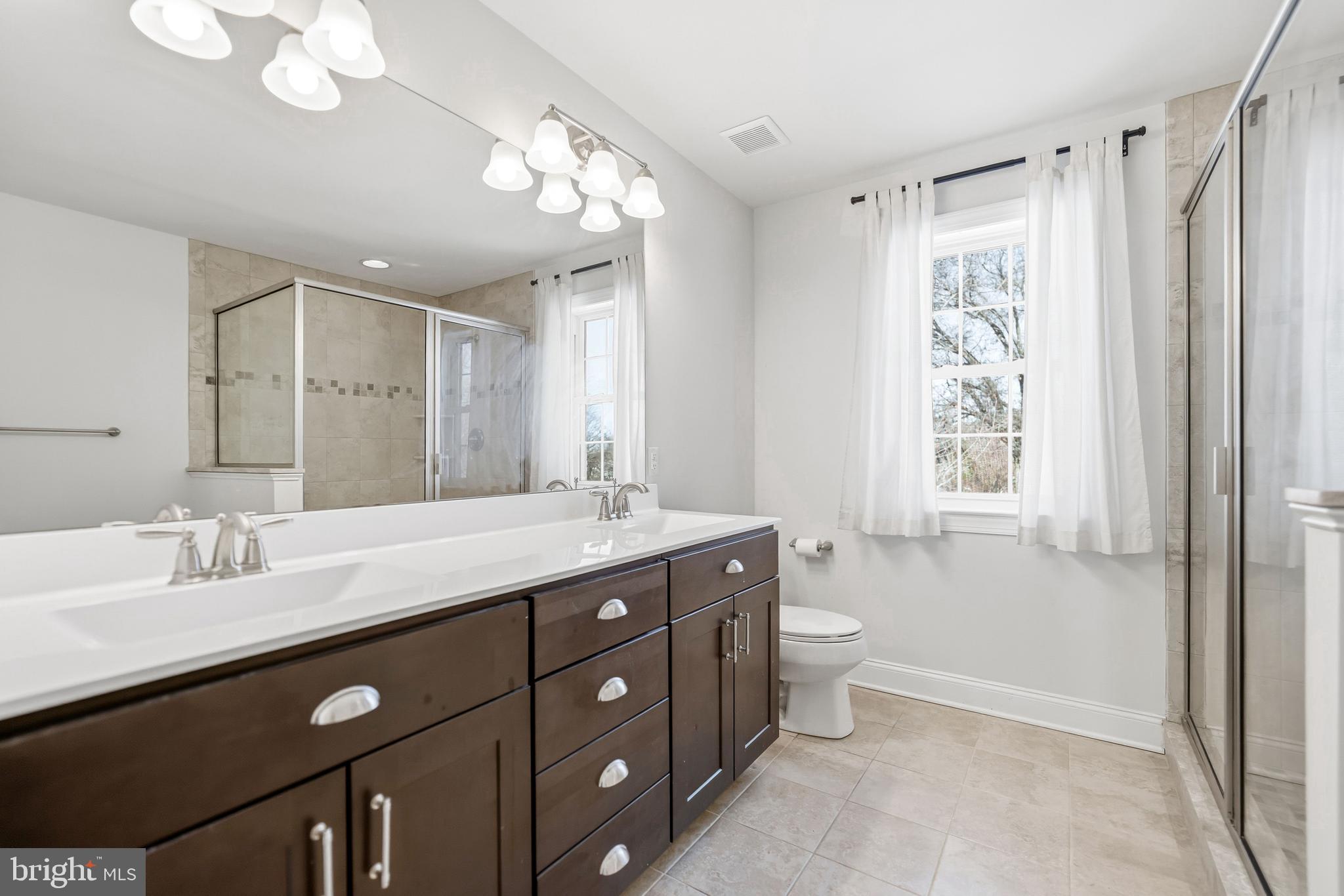 4777 Old Easton Road Doylestown, PA 18902 - Photo 15 of 26 a spacious bathroom with a double vanity sink a toilet and a mirror