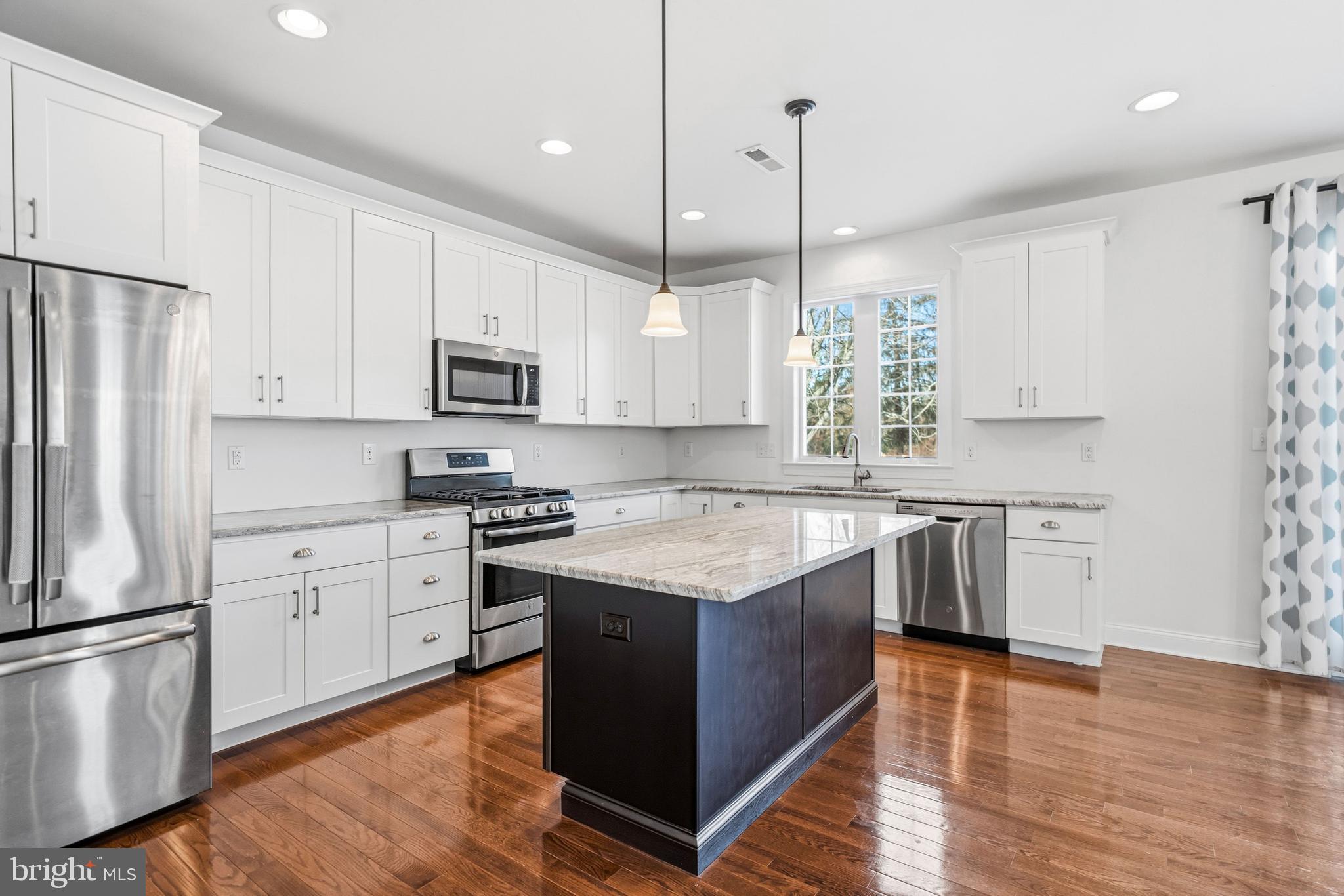4777 Old Easton Road Doylestown, PA 18902 - Photo 4 of 26 a kitchen with stainless steel appliances granite countertop a stove a sink and a refrigerator with wooden floor