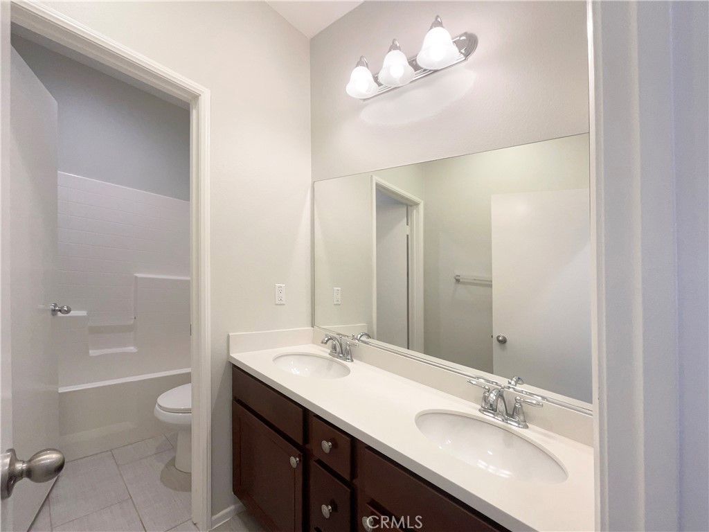 26625 Emperor Road Menifee, CA 92585 - Photo 12 of 24 a bathroom with a granite countertop sink a toilet a bathtub and shower