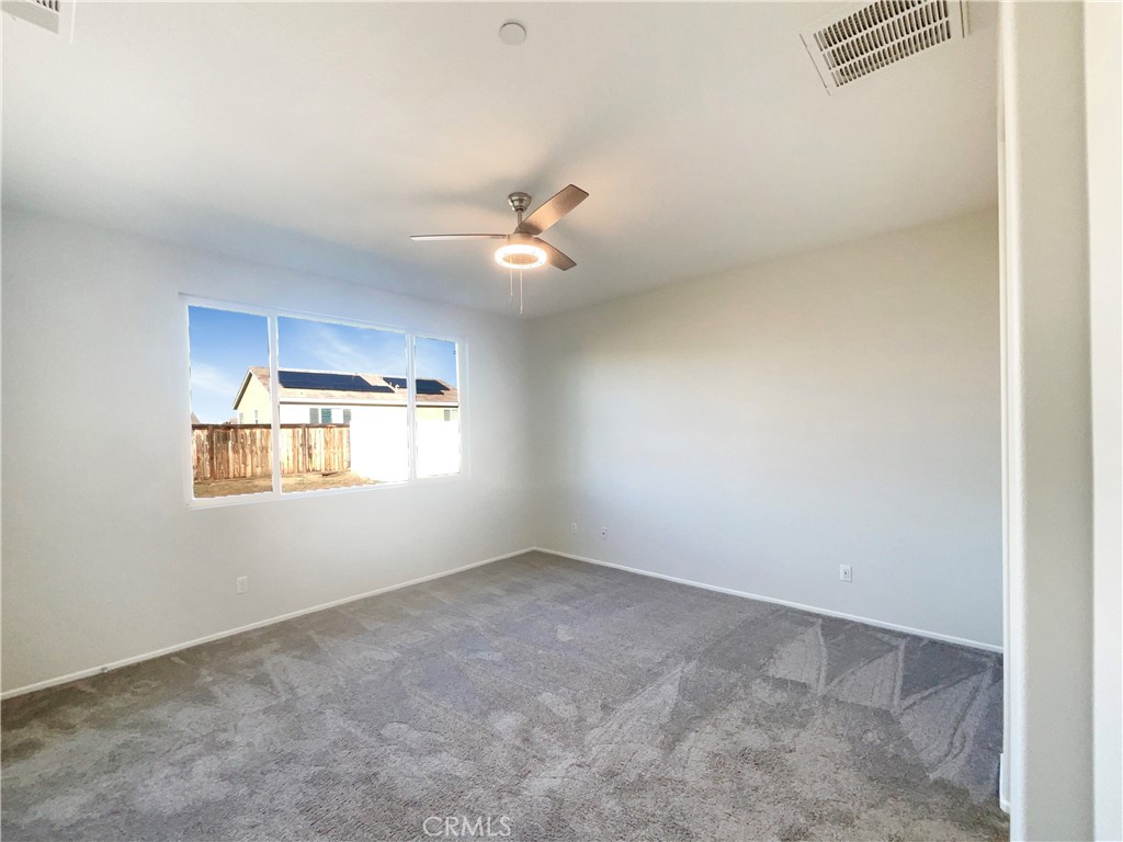 26625 Emperor Road Menifee, CA 92585 - Photo 17 of 24 an empty room with windows and ceiling fan