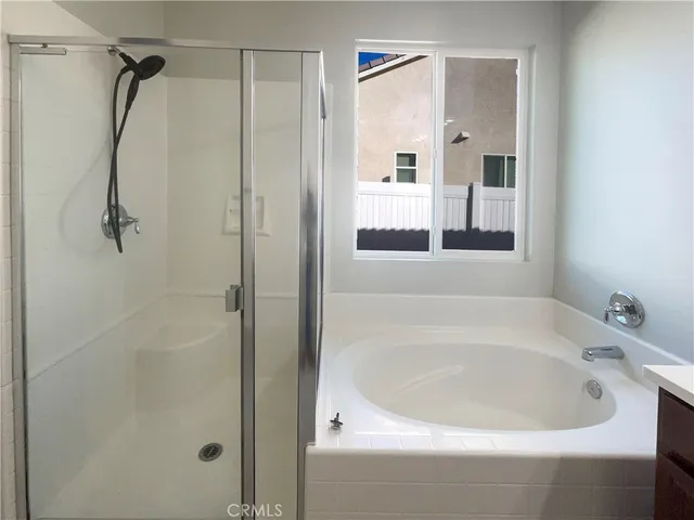 a white bath tub sitting next to a shower