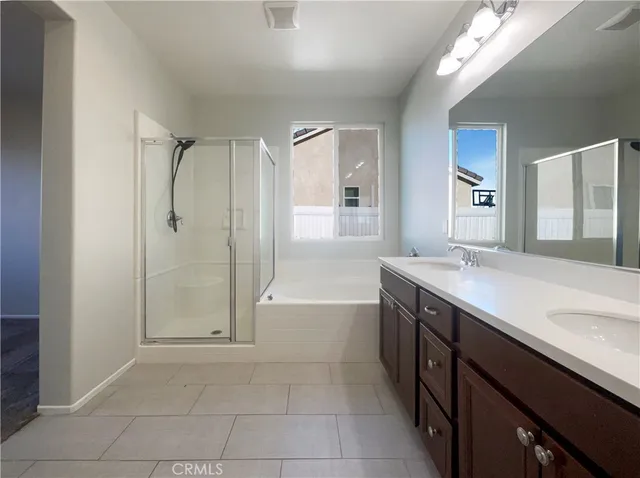 a spacious bathroom with a granite countertop sink a toilet a mirror and shower