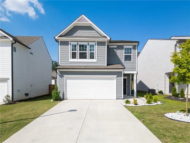 a front view of a house with a yard and garage