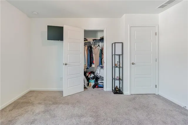 an empty room with closet and a chandelier