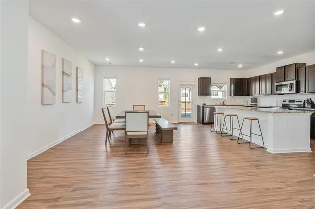 a kitchen with stainless steel appliances a dining table chairs and view living room