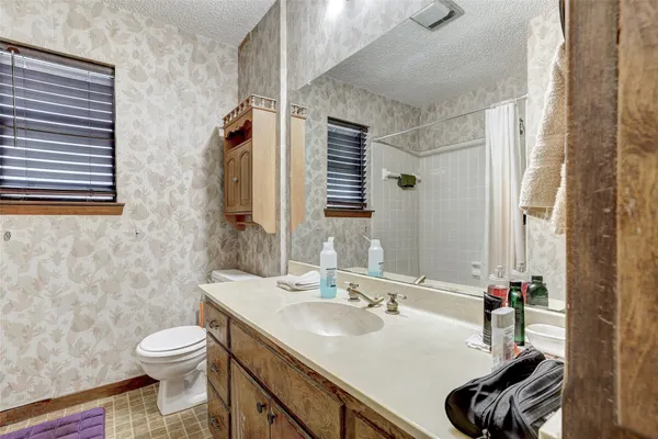 a bathroom with a granite countertop toilet sink and mirror