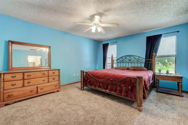 a spacious bedroom with a bed and a dresser