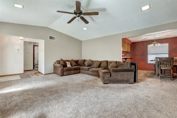 a living room with furniture and a ceiling fan