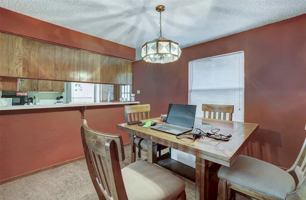 a view of a dining room with furniture a chandelier and wooden floor