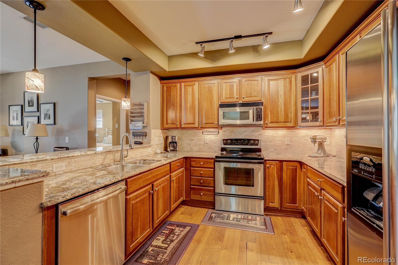 10556 Graymont Lane, Unit B Highlands Ranch, CO 80126 - Photo 12 of 40 a kitchen with stainless steel appliances granite countertop a stove a sink and a refrigerator