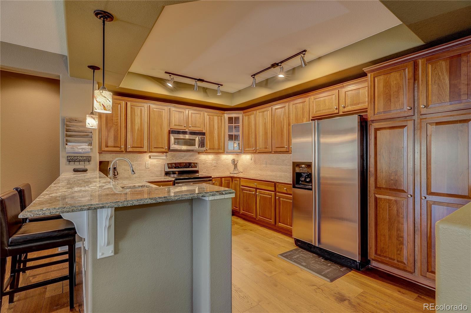 10556 Graymont Lane, Unit B Highlands Ranch, CO 80126 - Photo 13 of 40 a kitchen with stainless steel appliances granite countertop a sink refrigerator and cabinets