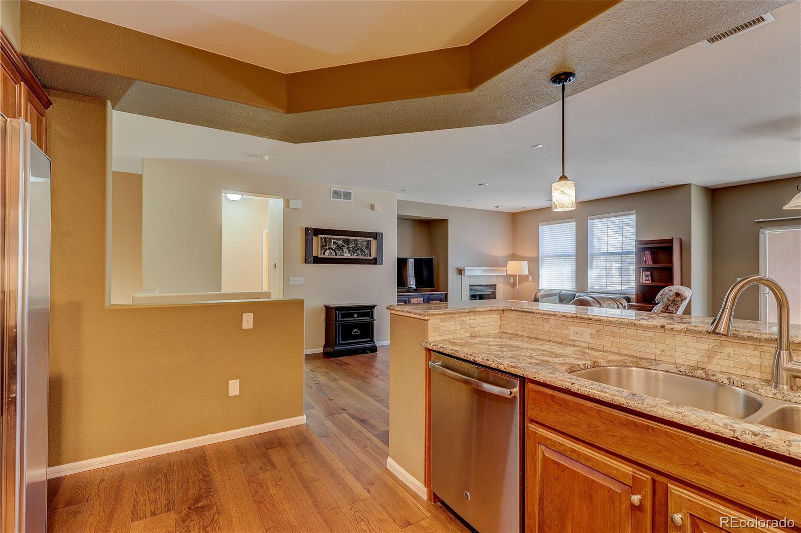 10556 Graymont Lane, Unit B Highlands Ranch, CO 80126 - Photo 15 of 40 a view of a kitchen with kitchen island a counter space a sink and wooden floor