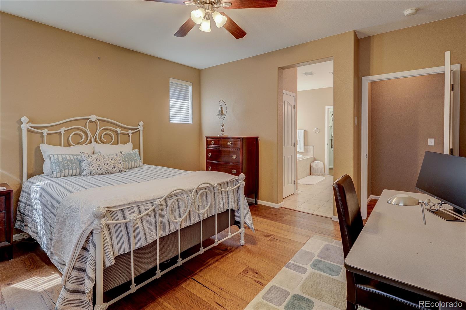 10556 Graymont Lane, Unit B Highlands Ranch, CO 80126 - Photo 22 of 40 a bedroom with a bed and wooden floor