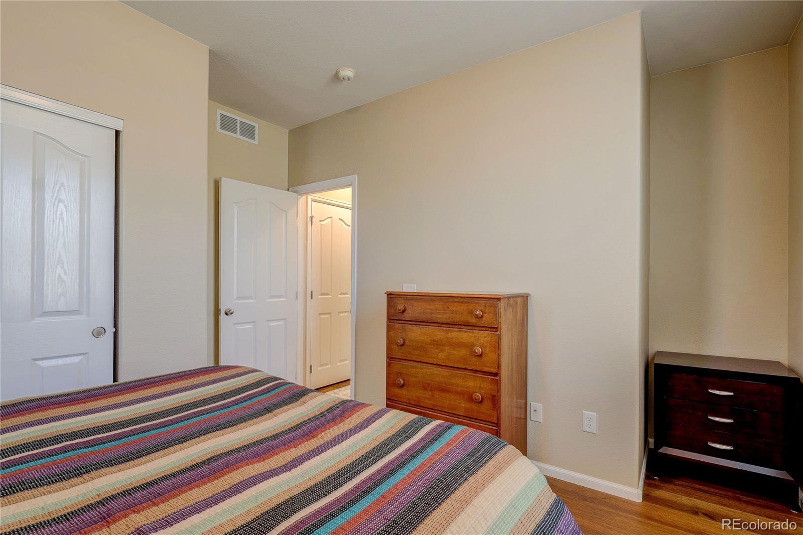 10556 Graymont Lane, Unit B Highlands Ranch, CO 80126 - Photo 25 of 40 a bedroom with a bed and a dresser