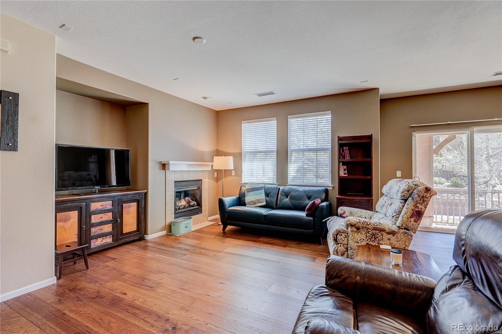 10556 Graymont Lane, Unit B Highlands Ranch, CO 80126 - Photo 4 of 40 a living room with furniture a flat screen tv and a fireplace