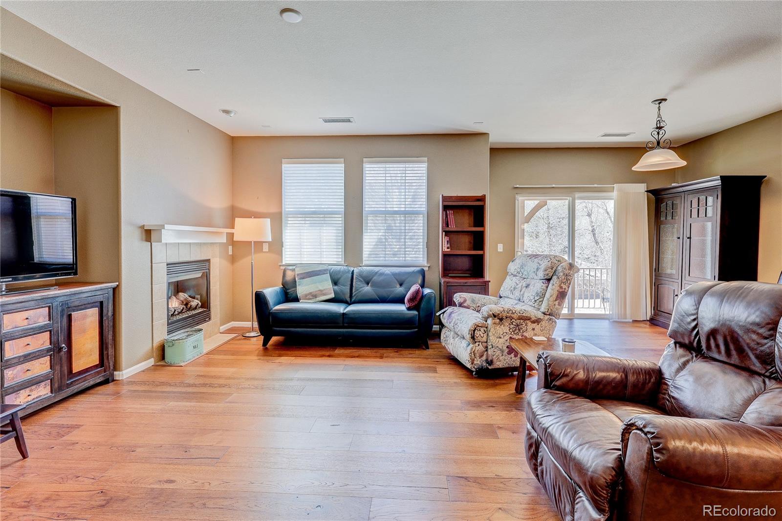 10556 Graymont Lane, Unit B Highlands Ranch, CO 80126 - Photo 6 of 40 a living room with furniture flat screen tv and a fireplace