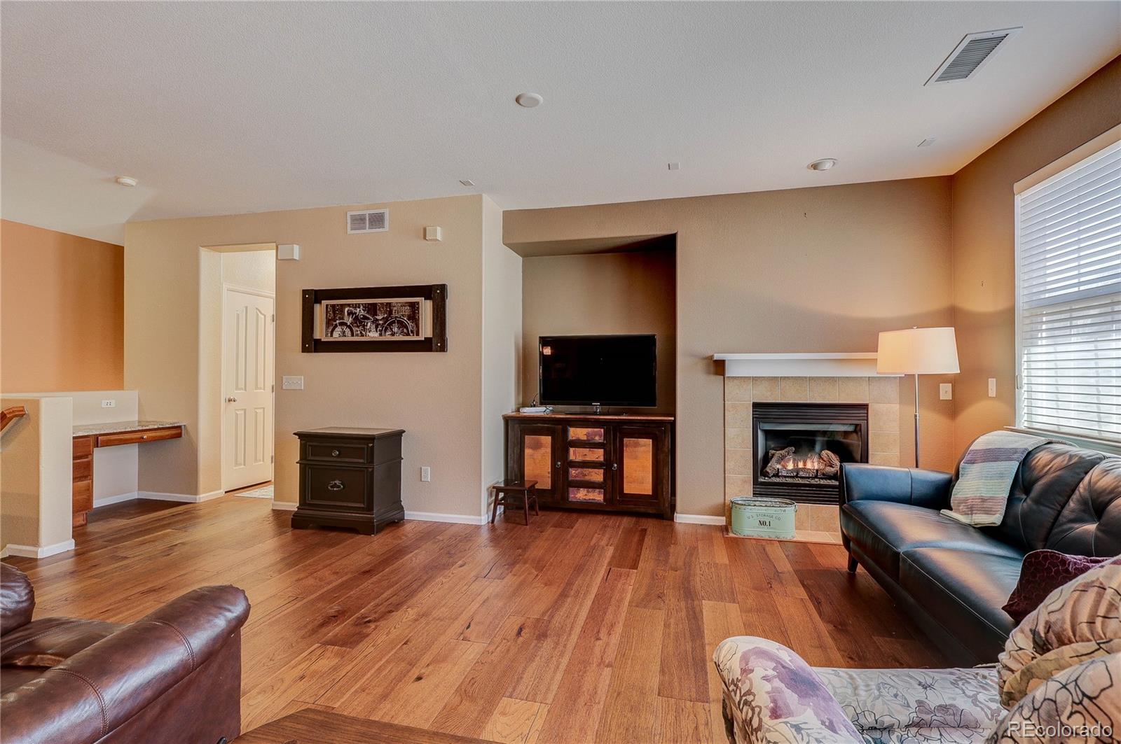 10556 Graymont Lane, Unit B Highlands Ranch, CO 80126 - Photo 10 of 40 a living room with furniture a fireplace and a flat screen tv