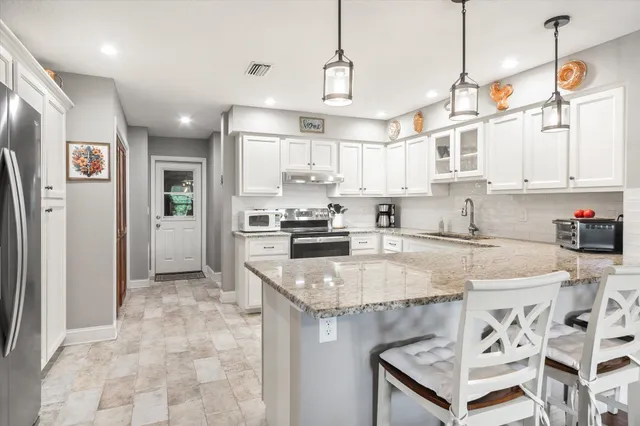 a kitchen with stainless steel appliances granite countertop a sink stove and refrigerator