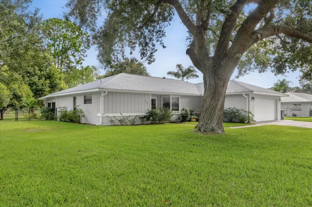 a front view of a house with a garden and trees