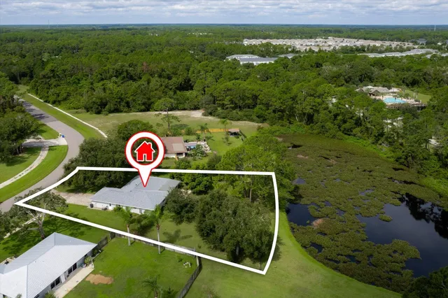 an aerial view of residential houses with outdoor space and lake view