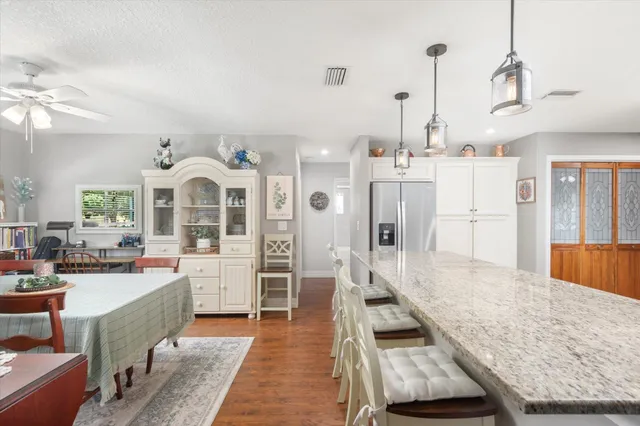 a large kitchen with kitchen island a large counter top space a sink stainless steel appliances and cabinets