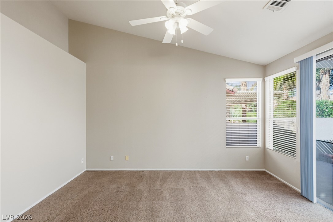 9034 Ridgepointe Way Henderson, NV 89074 - Photo 26 of 56 Angled high ceilings and sliding glass doors maximize natural light across the carpeted living space.