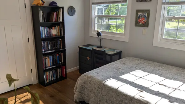 a bedroom with a bed and a book shelf