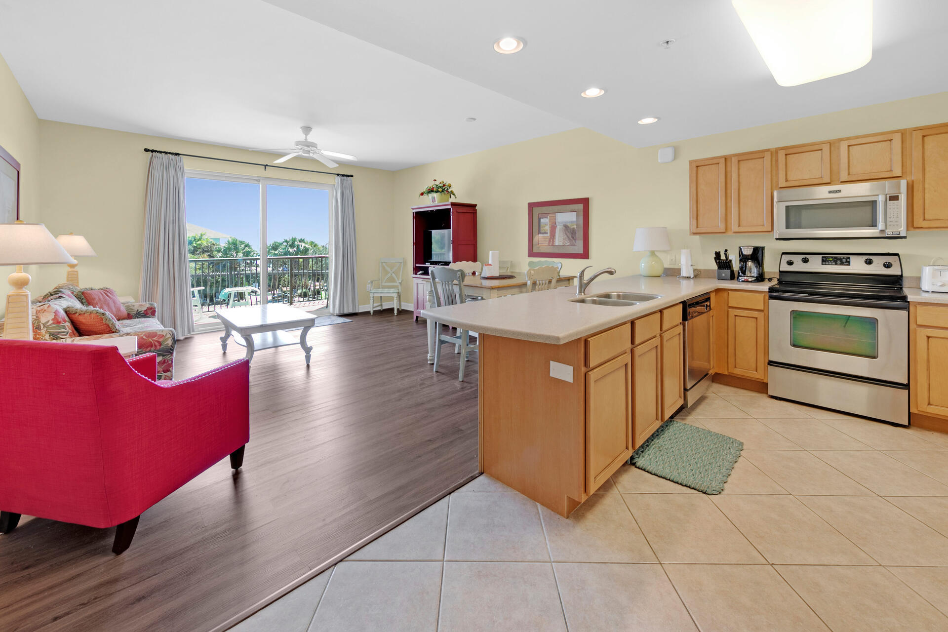 548 Sandy Cay Drive, Unit 309 Miramar Beach, FL 32550 - Photo 16 of 47 a kitchen with stainless steel appliances granite countertop a stove top oven a sink dishwasher a dining table and chairs with wooden floor