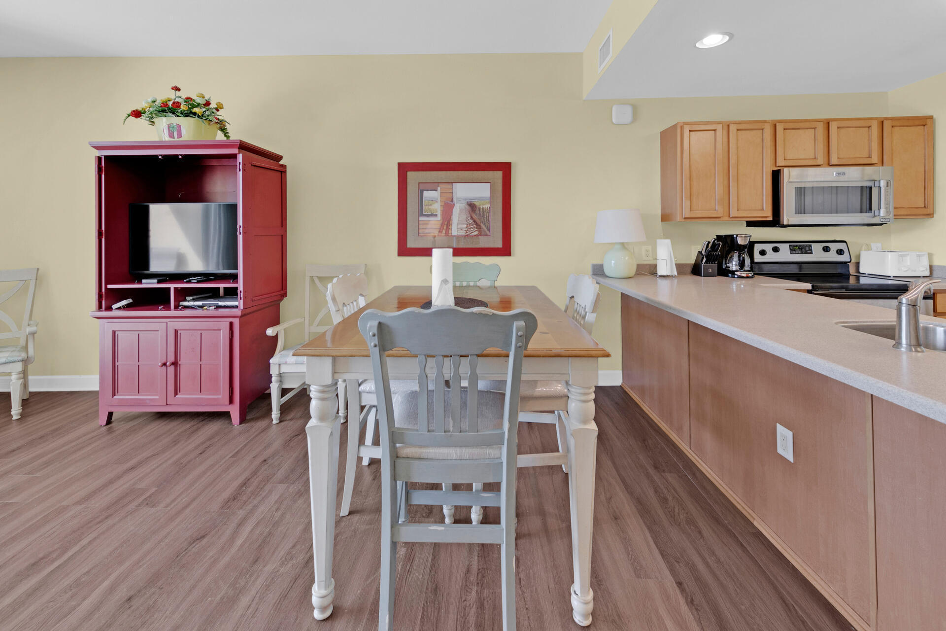 548 Sandy Cay Drive, Unit 309 Miramar Beach, FL 32550 - Photo 20 of 47 a kitchen with granite countertop a stove top oven a sink a dining table and chairs with wooden floor