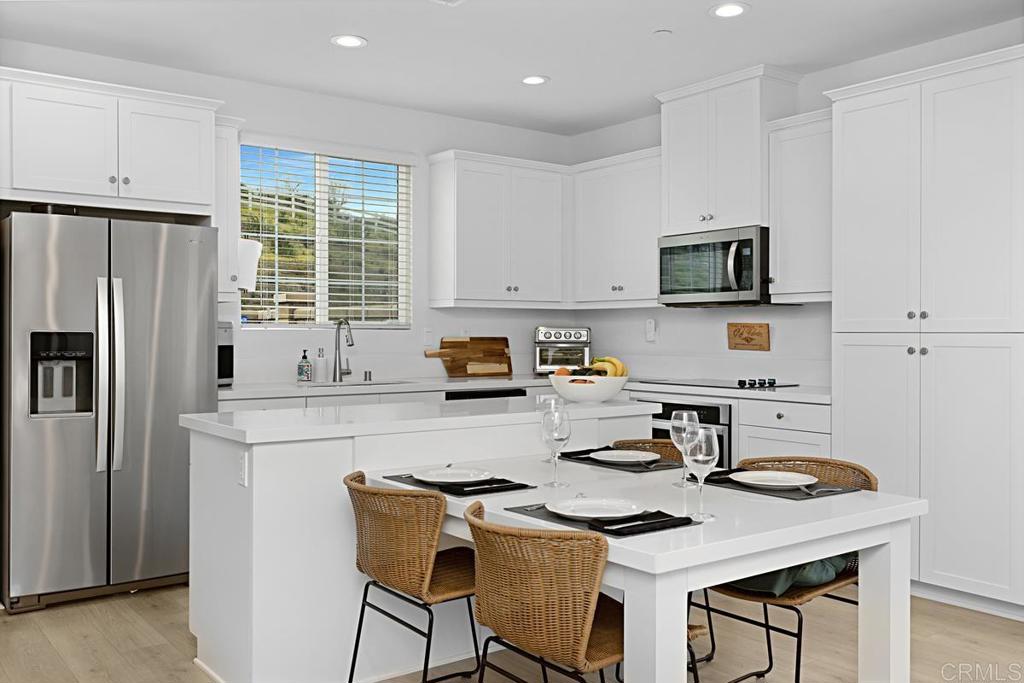 5410 Luna Way Bonsall, CA 92003 - Photo 11 of 37 a kitchen with stainless steel appliances a stove a sink a refrigerator and white cabinets