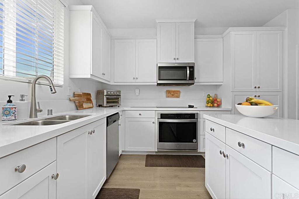5410 Luna Way Bonsall, CA 92003 - Photo 12 of 37 a kitchen with stainless steel appliances granite countertop a sink dishwasher stove and white cabinets