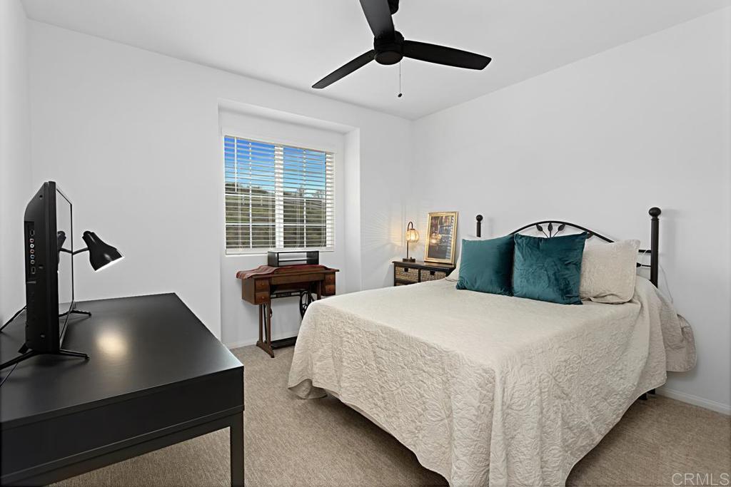 5410 Luna Way Bonsall, CA 92003 - Photo 25 of 37 a bedroom with a bed and a chandelier