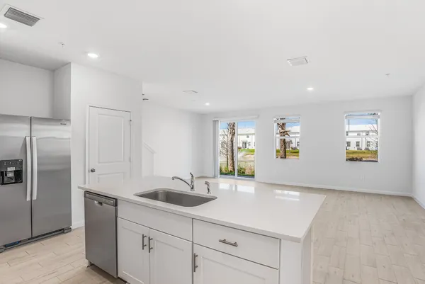 a kitchen with kitchen island a sink stainless steel appliances and cabinets