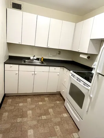 a kitchen with a stove and white cabinets