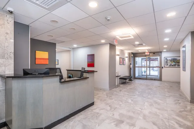 a view of a big room with a large window and wooden floor