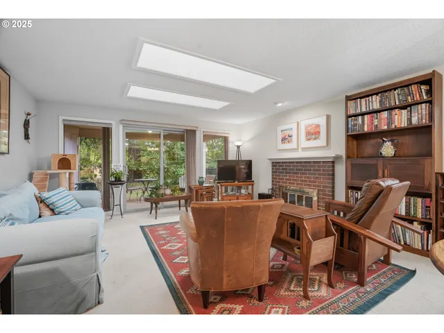 a living room with fireplace furniture and a large window