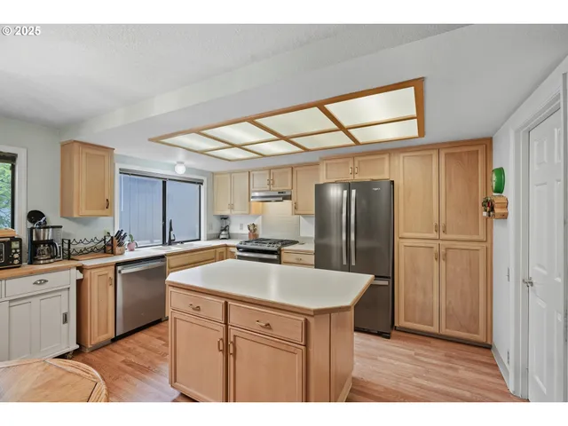 a kitchen with stainless steel appliances granite countertop a refrigerator and a sink