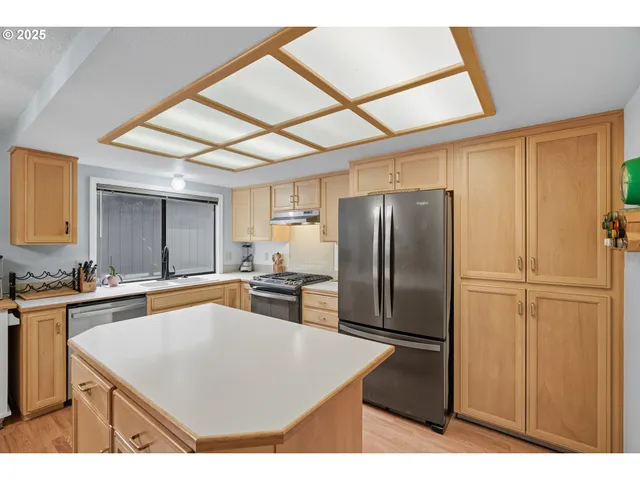 a kitchen with stainless steel appliances a refrigerator sink and cabinets