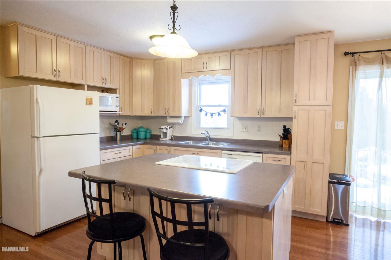 10518 Getz Road Mount Carroll, IL 61053 - Photo 3 of 7 a kitchen with stainless steel appliances granite countertop a refrigerator a stove a sink dishwasher and a refrigerator with wooden floor