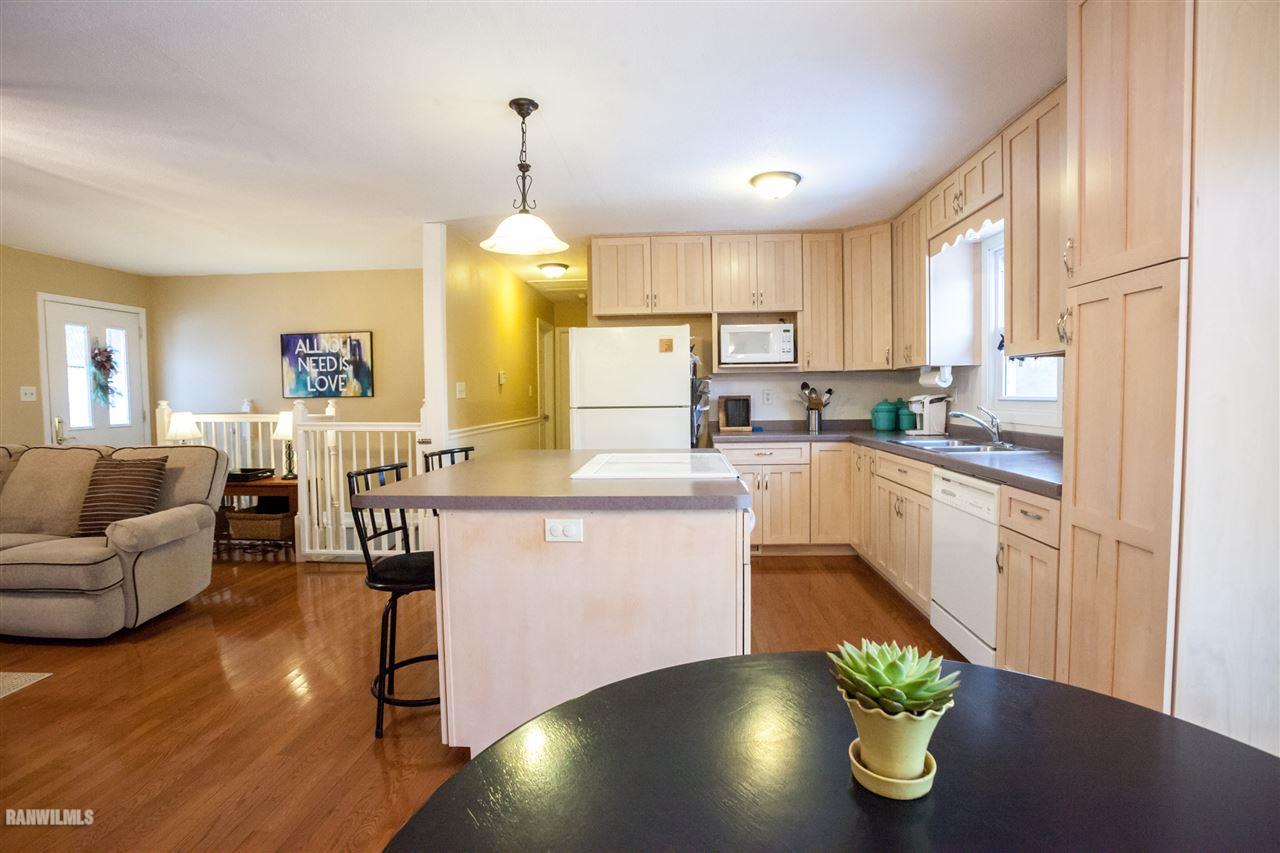 10518 Getz Road Mount Carroll, IL 61053 - Photo 4 of 7 a kitchen with a table chairs stove and cabinets