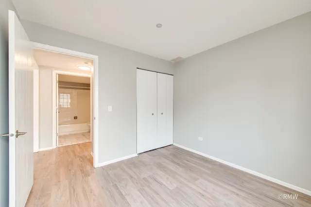 a view of a room with wooden floor and a bathroom