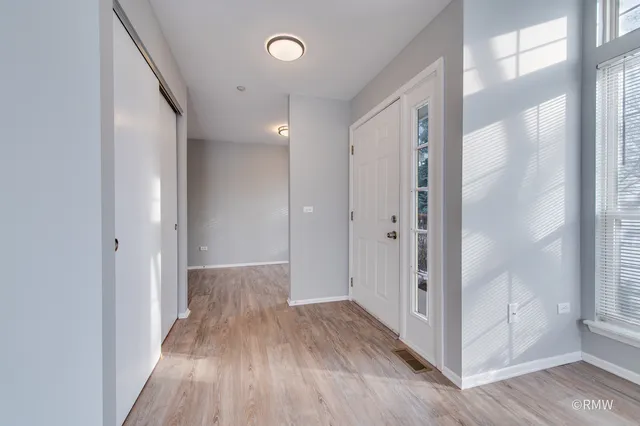 a view of a hallway with wooden floor and closet area