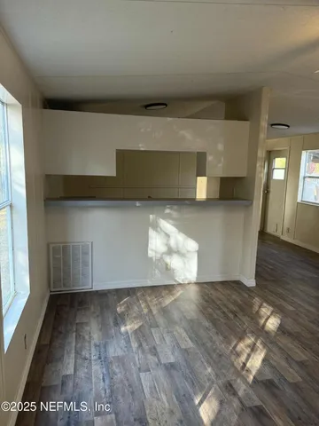 a view of empty room with wooden floor
