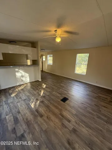 a view of empty room with wooden floor