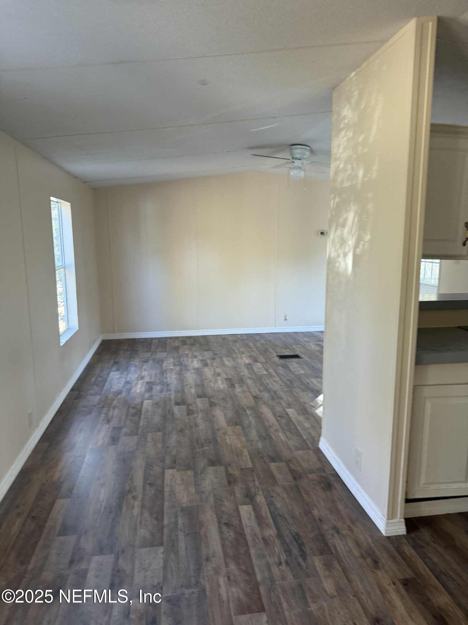 550 Interlachen Boulevard Interlachen, FL 32148 - Photo 7 of 15 an empty room with wooden floor and windows