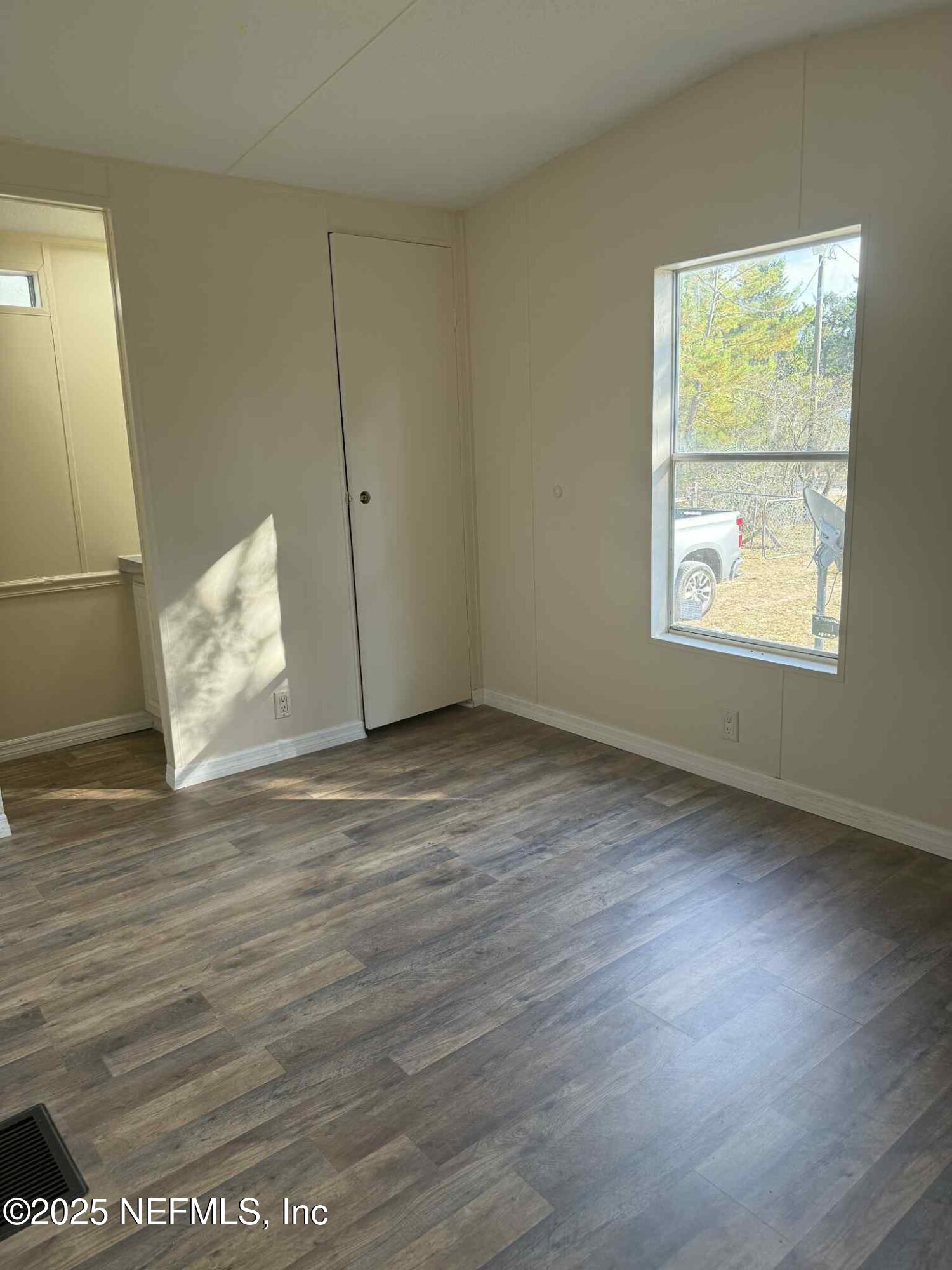 550 Interlachen Boulevard Interlachen, FL 32148 - Photo 10 of 15 an empty room with wooden floor and windows