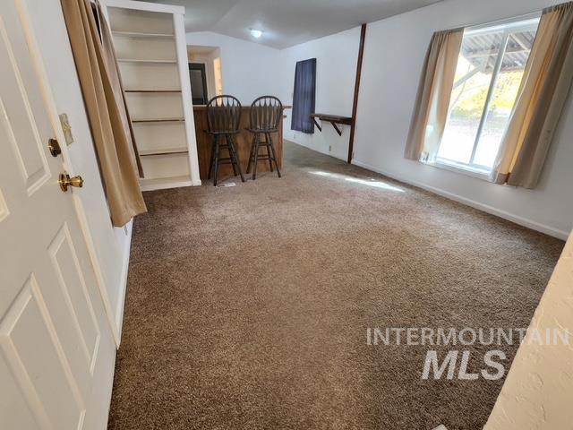 1220 North 4th Street Parma, ID 83660 - Photo 8 of 23 Carpeted spare room featuring lofted ceiling and baseboards