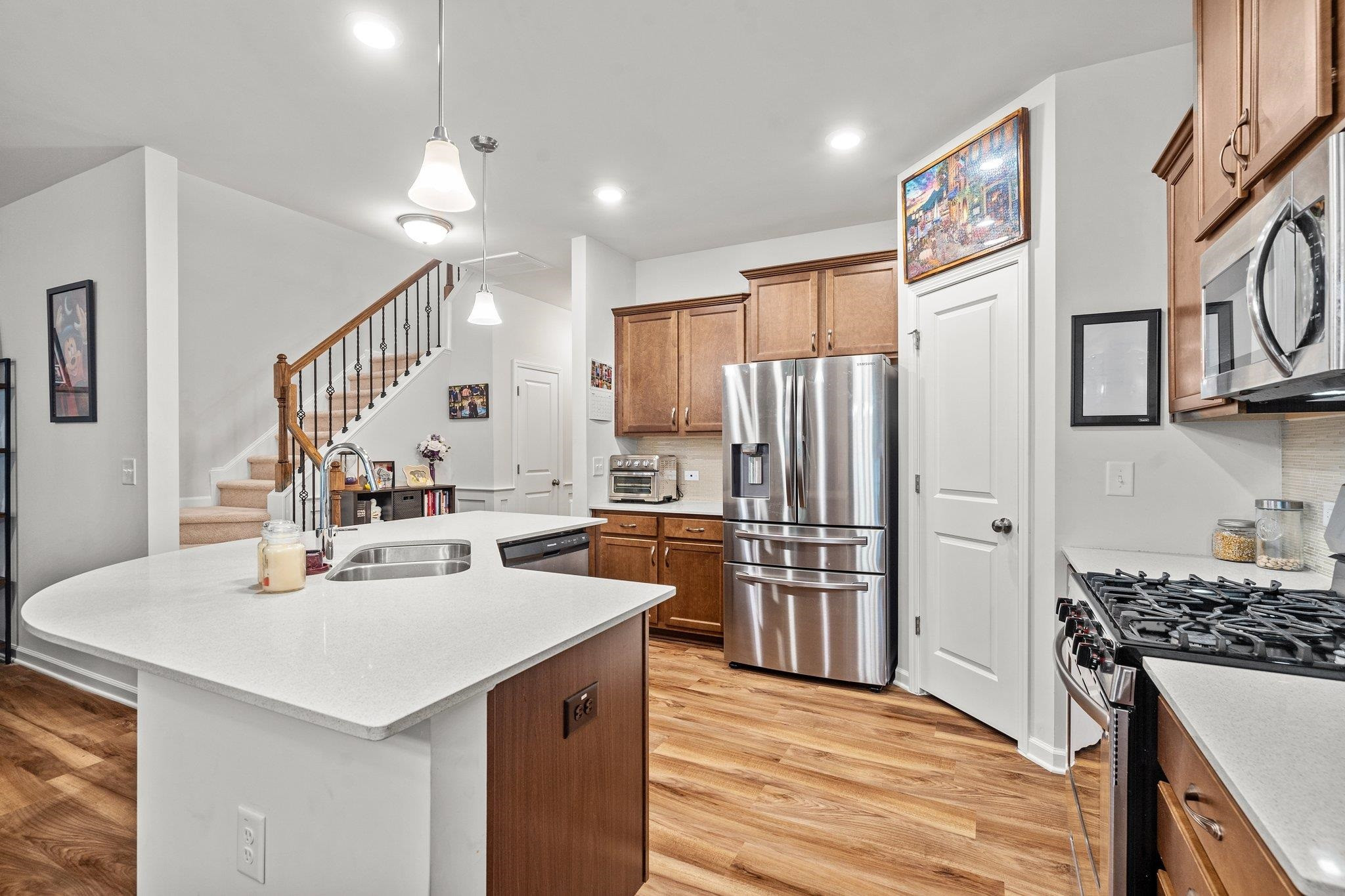 6085 Beale Loop Raleigh, NC 27616 - Photo 6 of 42 a kitchen with a sink a kitchen island stainless steel appliances cabinets and a counter top space