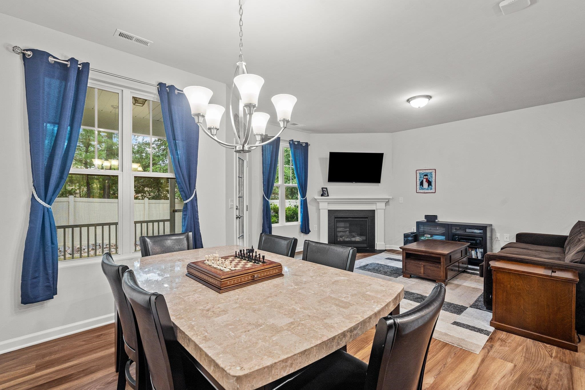 6085 Beale Loop Raleigh, NC 27616 - Photo 10 of 42 a view of a dining room with furniture a chandelier windows and wooden floor