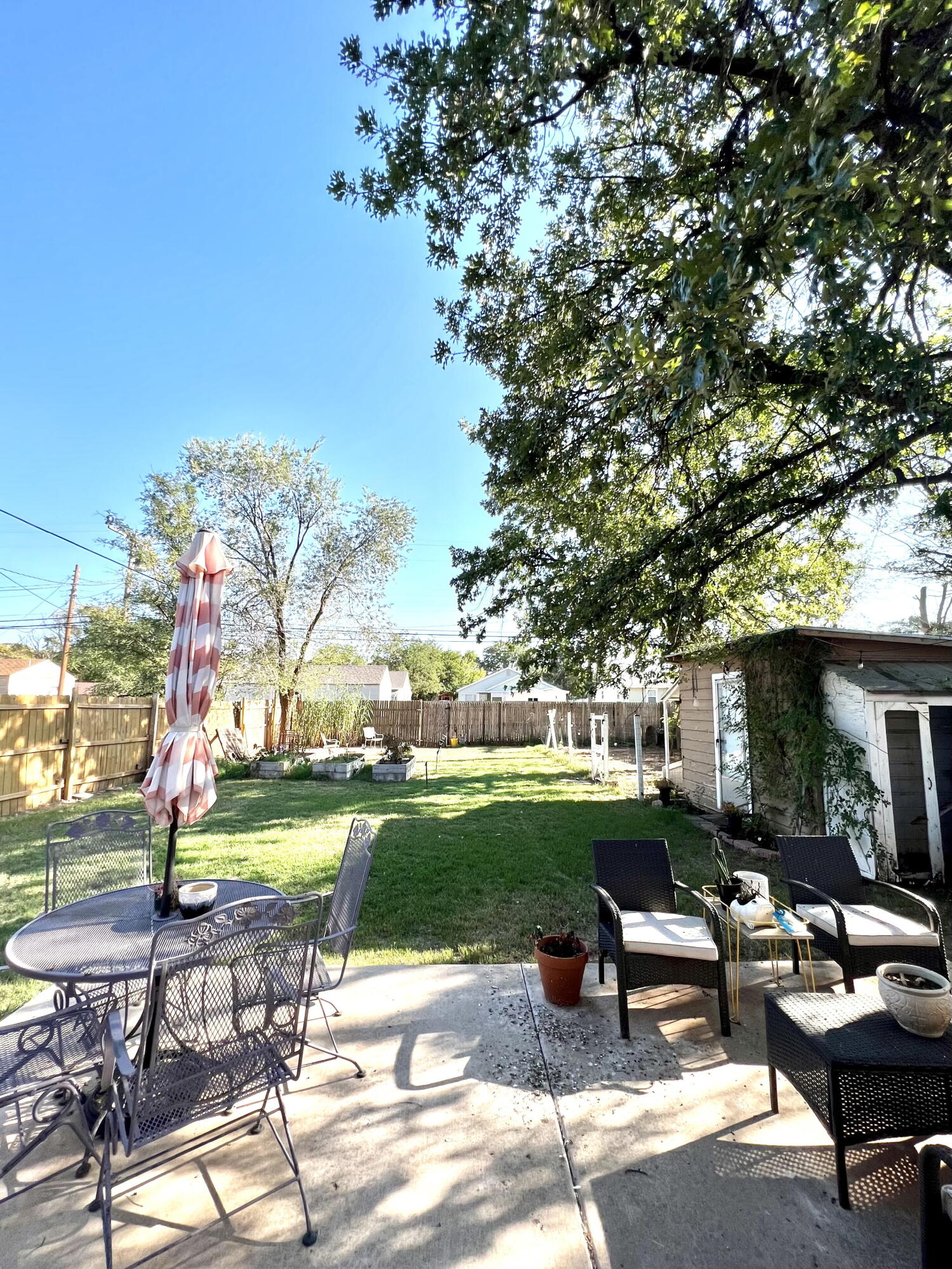 2111 23rd Street Lubbock, TX 79411 - Photo 14 of 15 a view of a patio with dining table and chairs with a yard